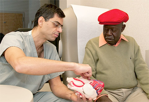 Doctor shows a Veteran a model of the heart