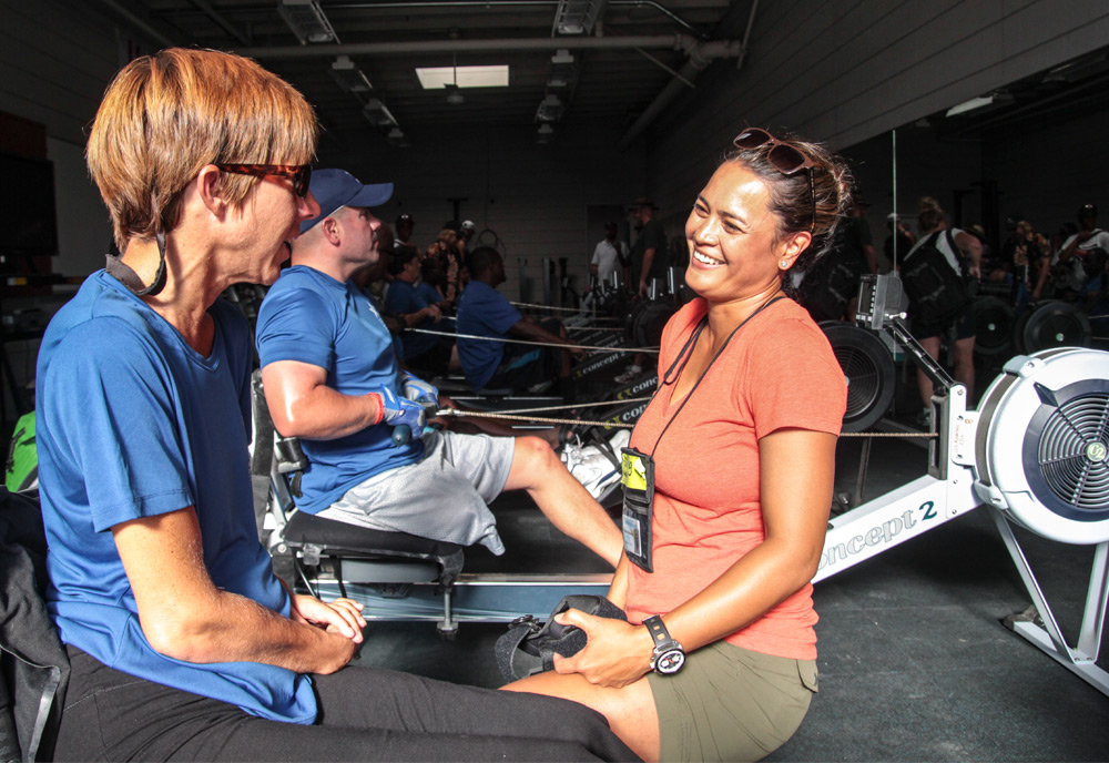 Two women talk and smile in an exercise room