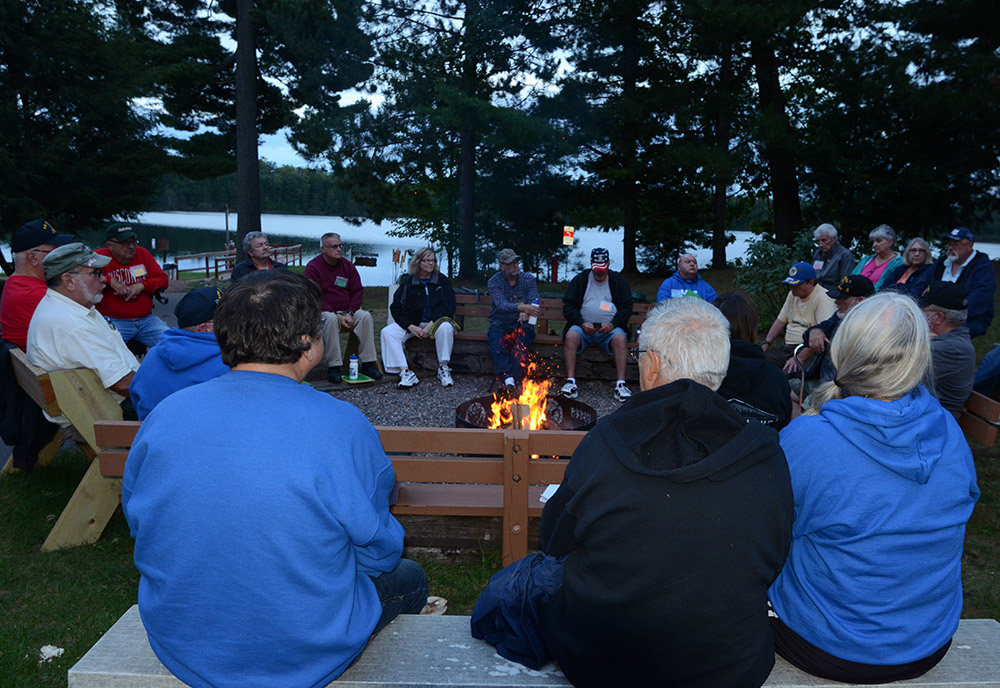 Veterans sitting around a camp fire.
