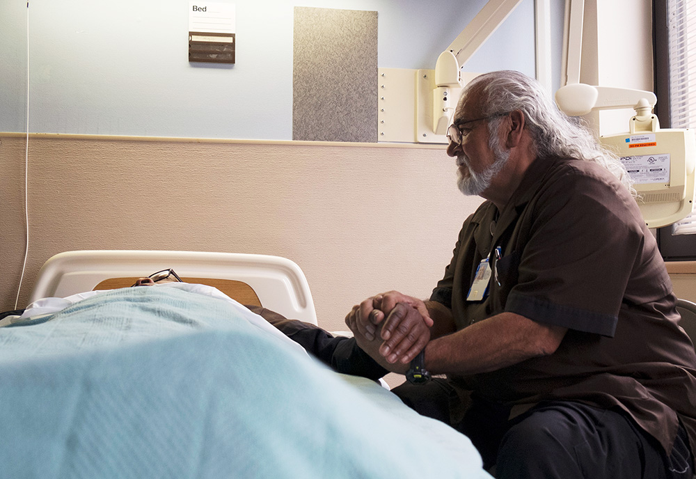 Images of Julian Scadden at the bedside of a dying Veteran. 