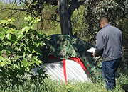 A member of the VA Central California Health Care System’s Hepatitis C Clinic approaches a      homeless person’s tent in Fresno, Calif. 