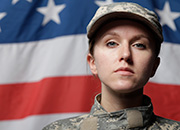 Female soldier standing in front of American Flag
