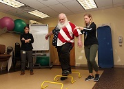 Army Veteran Gary Lucas navigates a hurdle exercise with the help of study coordinator Lydia Paden