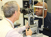 Doctor peforming an eye exam on a male Veteran patient