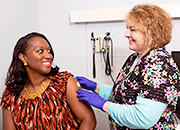 Woman receives flu shot from nurse.