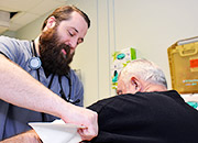 A nurse wraps a Veteran's arm with a blood pressure cuff