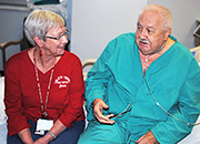 Woman volunteer sits with a Veteran patient