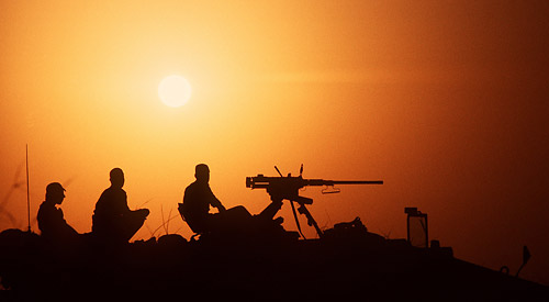 Silhouette of three soldiers in the sunset