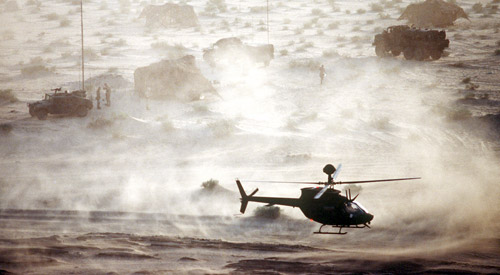 Aerial photo of a helicopter flying over the desert