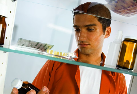 man checking medicine in a medicine cabinet
