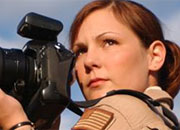 Female military photographer in uniform with camera.