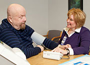 a woman helps a man take his blood pressure