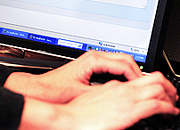 hands at a keyboard and a computer screen