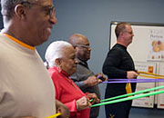 Men and women in the MOVE! program stretch colorful resistance bands