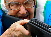 A senior man aims a rifle