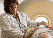 Woman attending to a man lying on a CT scanner