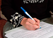 Woman's hand filling out a survey with a pen
