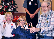 Children and elderly man enjoy holiday cookies.