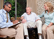A woman and her elderly father speak with a doctor