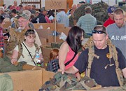 Homeless Veterans pick out new clothes from boxes in a large room