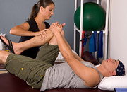woman helping a man stretch his leg