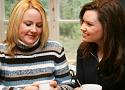 two women talk over coffee