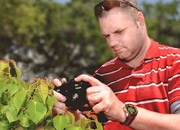 Veteran outside takes a close up picture of a bush
