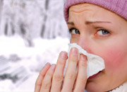 Woman outside in the cold blowing her nose