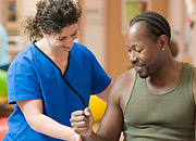 A physical therapist helps a man move his arm