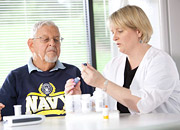 A nurse instructs a senior Veteran on medications