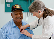 A doctor uses a stethoscope to listen to the heart of a Vietnam Veteran