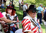 A Veteran and his wife talk to other Veterans in a park