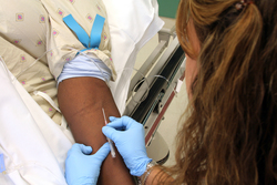 a nurse putting a needle into a patient's arm