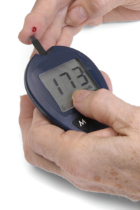 glucometer and test stip being used on finger