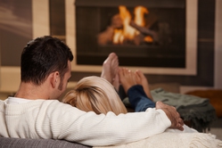 couple relaxing in front of fireplace
