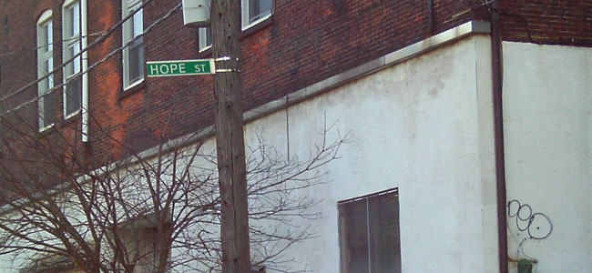 The street sign says Hope Street.  That’s a few blocks away from where I used to drop dope.  That was probably a great place to have a job at one point.  Somebody probably raised their family, working in that building on Hope Street.  Now it’s like ghetto. It’s graffiti on the wall. Everybody hopes for something better.