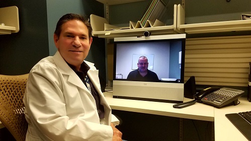 Telehealth practitioner Dr. Paul Maas (foreground) is joined via video by Rod Miles, facility telehealth coordinator at Bay Pines VA Healthcare System. Courtesy VA.gov.