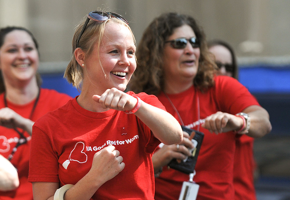 Smiling women wearing red t-shirts exercise outside