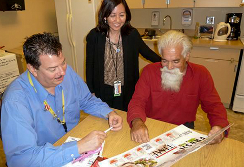 Occupational therapists Thomas Tousignant and Dorene Doi consult with Veteran Ralph Guillen to create timelines for a healthy future.