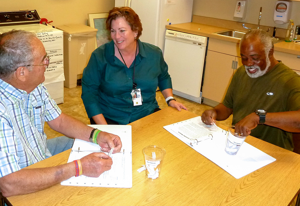 Karen Duddy, Occupational Therapy Supervisor, and Veterans Bill Armstrong  and Olester McNary participate in Doc Talk- a game in which Veterans learn to better communicate with health care providers.