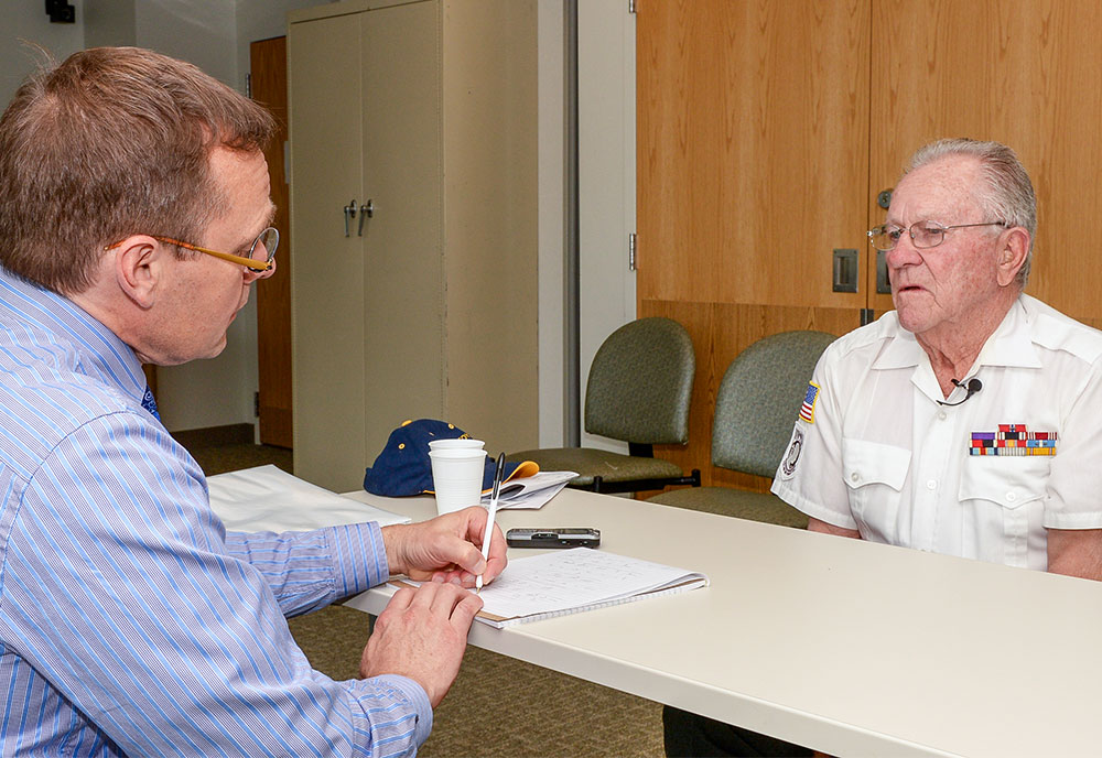 doctor taking notes as patient relays his story