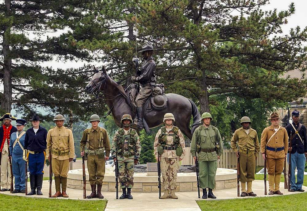 Eleven soldiers wearing different uniforms depicting the history of the Army