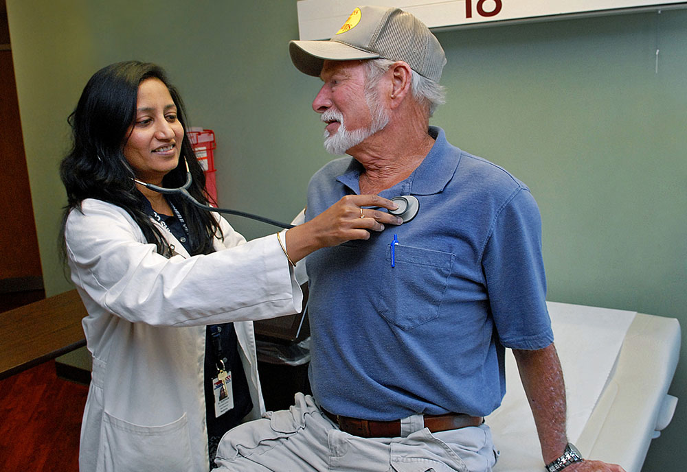 A doctor listens to a patient's heartbeat with a stethoscope. 