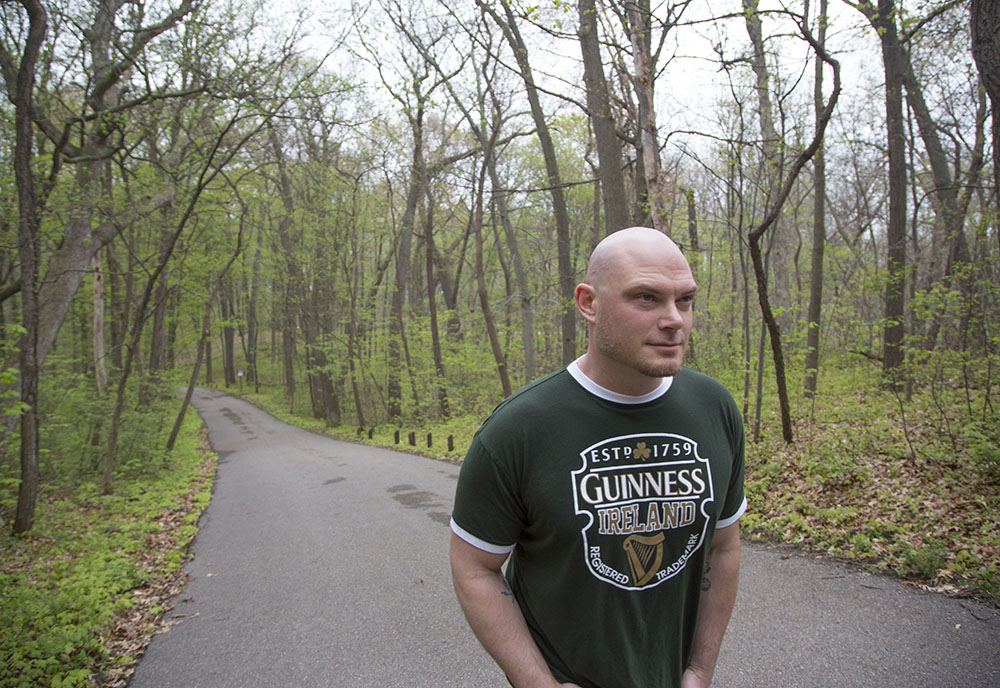 Male Veteran walking down a rural road surrounded by trees