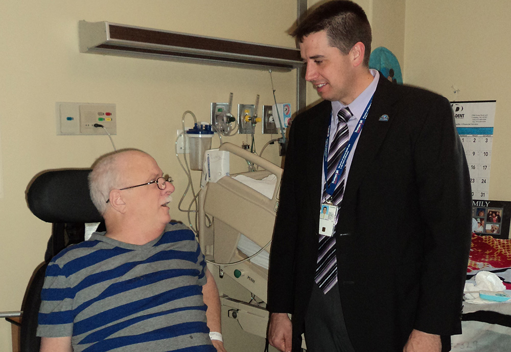 VAMC Director Isaacks visits with Veteran patient 