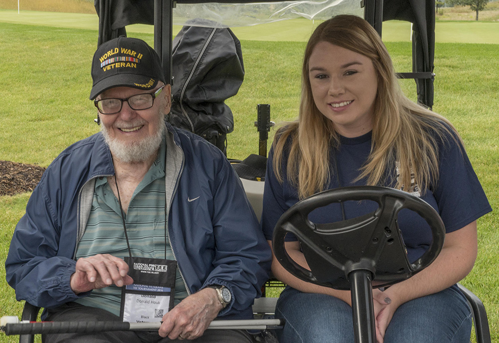 Veteran and volunteer in golf kart