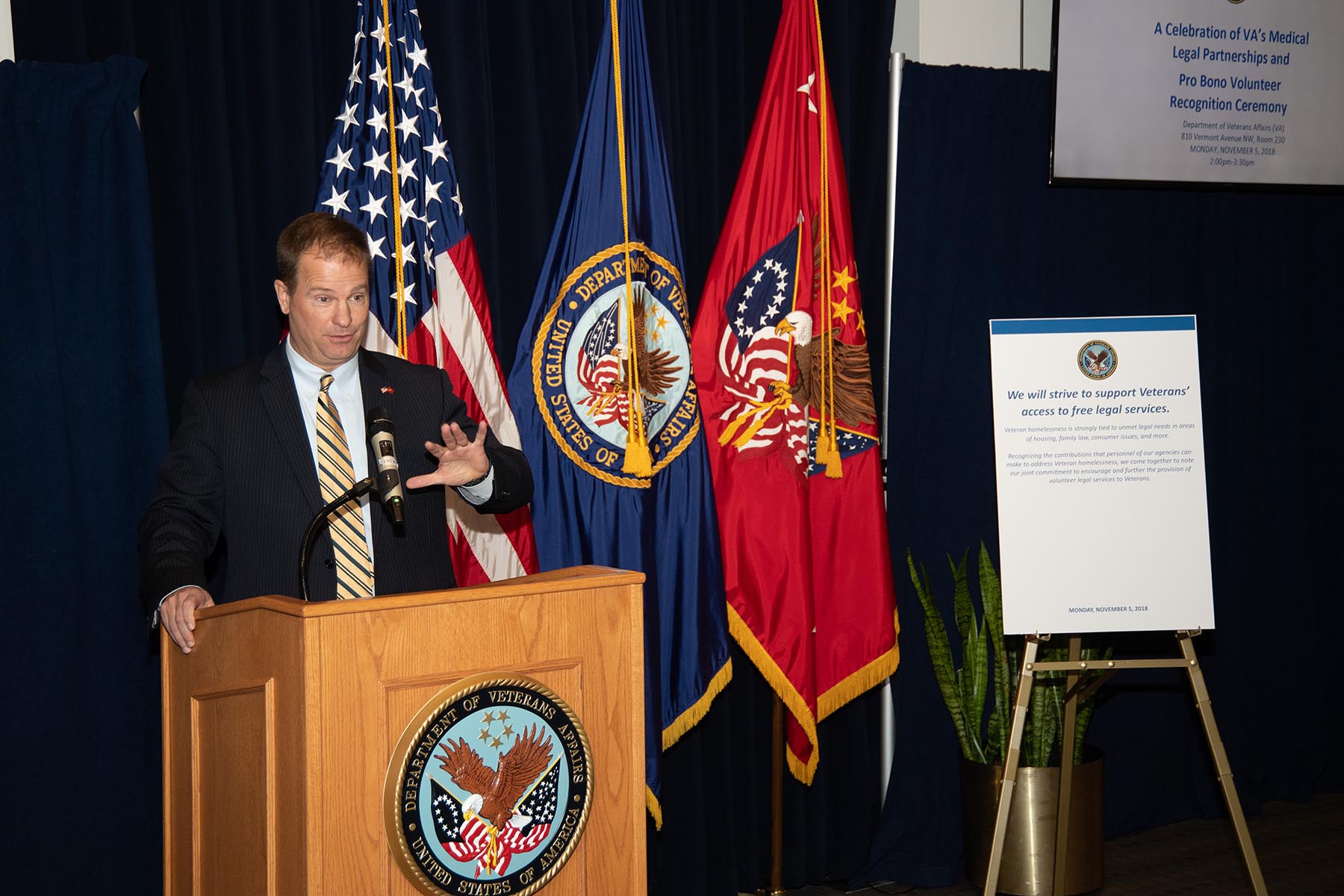 Male speaking at podium with Department of Veterans of Affairs seal on the front.