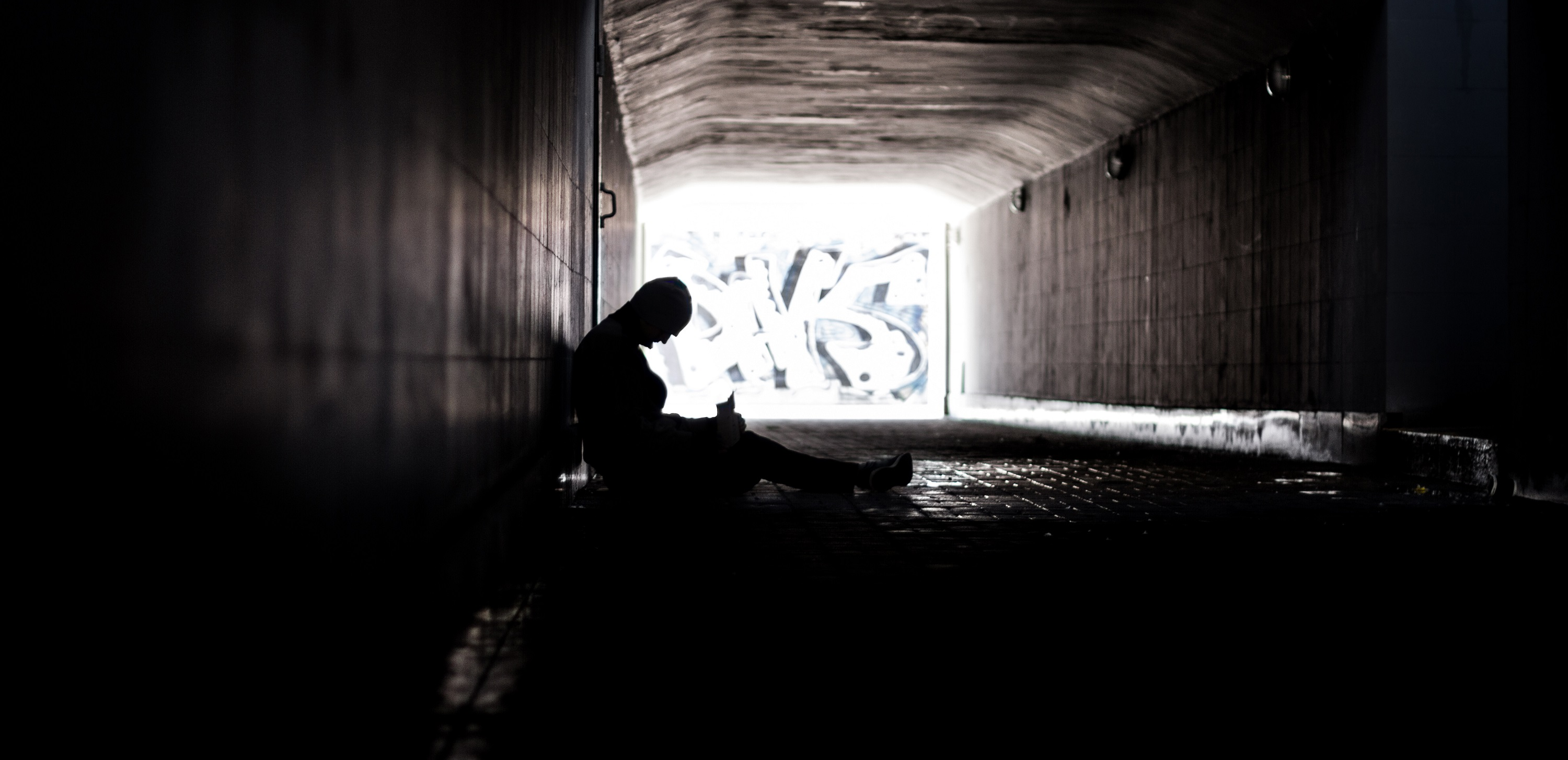 a person sitting in a dark tunnel