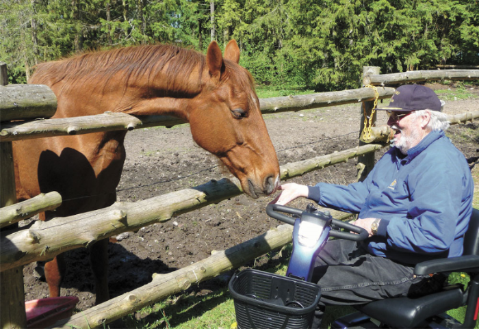 Brian Pettyjohn in wheelchair feeding a horse