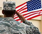 A soldier salutes to the US national flag.